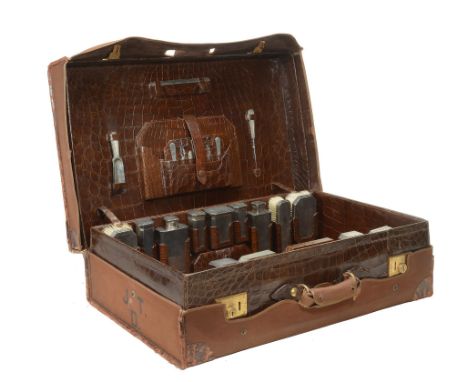 An early 20th century crocodile skin suitcase with silver fittings by...  An early 20th century crocodile skin suitcase with 