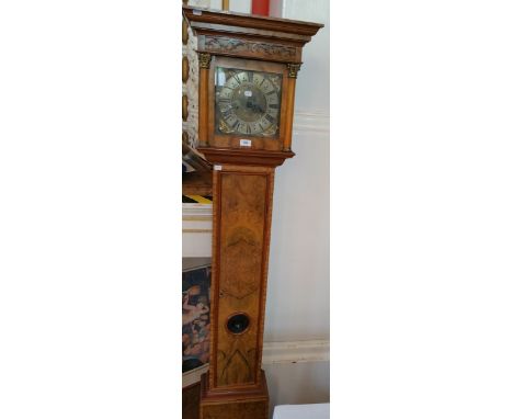 A Georgian style walnut longcase clock with brass chapter ring, striking movement, pendulum window, raised on a box base with