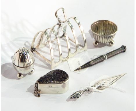 A silver four-division toast rack, a silver box of teardrop shaped form, a silver trowel pattern bookmark, a silver pepperett