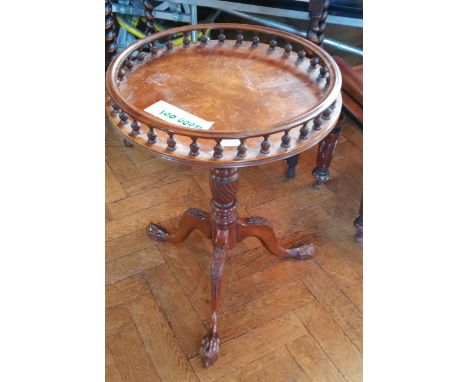 A Georgian style mahogany circular top occasional table, the open gallery with spindle supports, on turned column, with carve