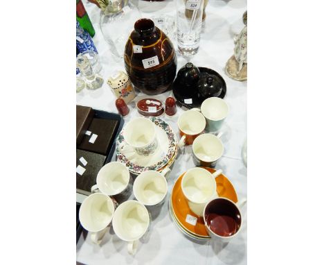 A Susie Cooper cruet set, comprising salt , pepper and mustard, cream decoration on a dark brown ground, a Winchcombe style v