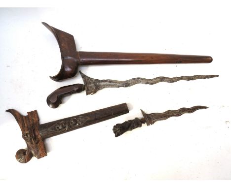 A 19th Century Indonesian Kris/Keris dagger with carved hardwood grip joining a wavy tapering blade, with scabbard, together 