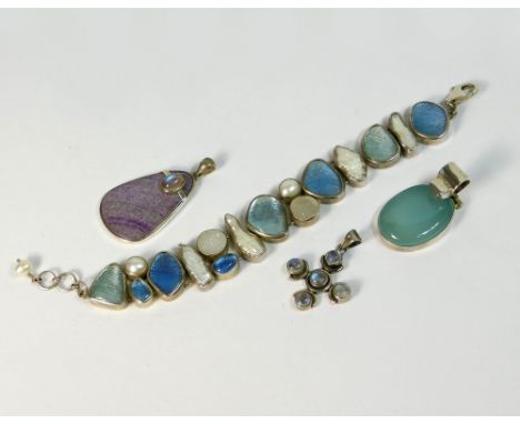 PENDANTS ETC. A silver mounted sodalite & moonstone pendant drop, a silver & moonstone cross pendant & a hinged silver & agat