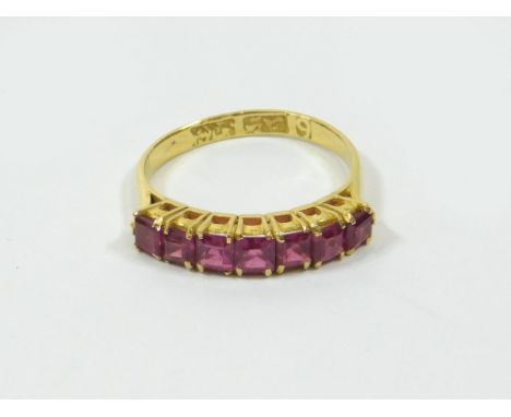 GOLD RING. A high purity gold ring, set a row of se en square cut pink stones, possibly synthetic rubies. Stamped marks. Size