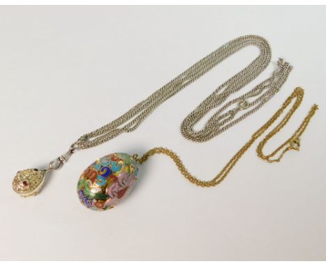 EGG PENDANTS. A large gilt metal & cloisonne enamelled egg pendant on chain, length 3.5cm. Also, a smaller garnet set egg pen