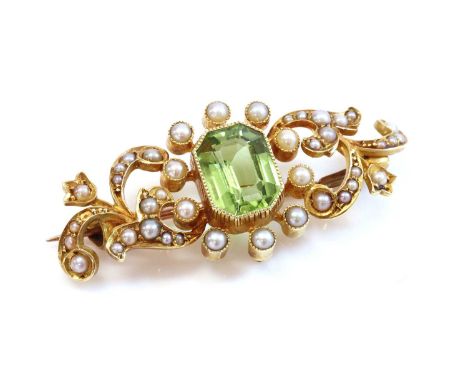 A late Victorian peridot and split pearl scrolling bar brooch, c.1900,with an octagonal step cut peridot, milligrain set to t