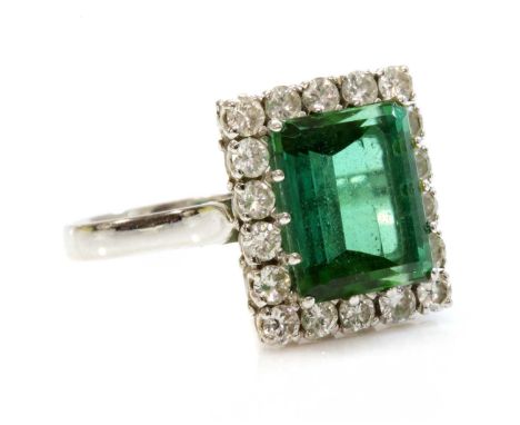 A white gold tourmaline and diamond rectangular cluster ring,with an emerald cut green tourmaline, claw set to the centre. A 