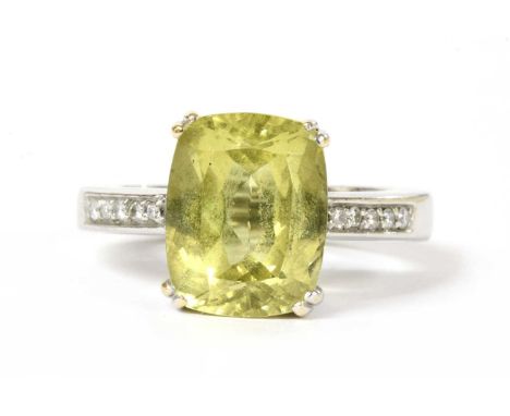 A gold heliodor and diamond ring, with a cushion cut heliodor or yellow beryl, 12.90 x 10.20 x 7.38mm, double claw set to sho