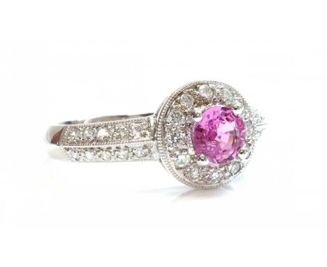 An 18ct white gold pink sapphire and diamond halo cluster ring,with a circular mixed cut pink sapphire, with a stated weight 