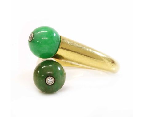 A two stone jade bead and diamond crossover ring, by Cartier,with two jade beads, each with a brilliant cut diamond, rub set 