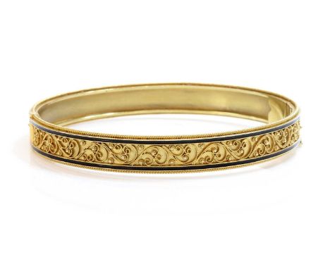 A Victorian archaeological revival Etruscan style gold and enamel hinged bangle, c.1870,the flat section oval hinged bangle w
