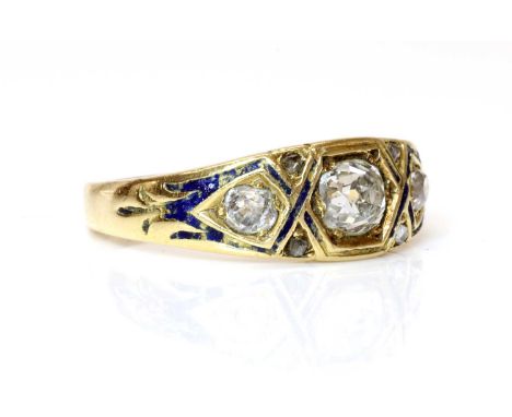 A Victorian three stone graduated diamond and enamel ring, c.1860, with a cushion cut diamond, grain set to the centre. A cus