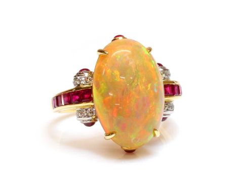 An opal, ruby and diamond cluster ring,with an oval cabochon opal, four claw set to the centre. Arched shoulders, channel set