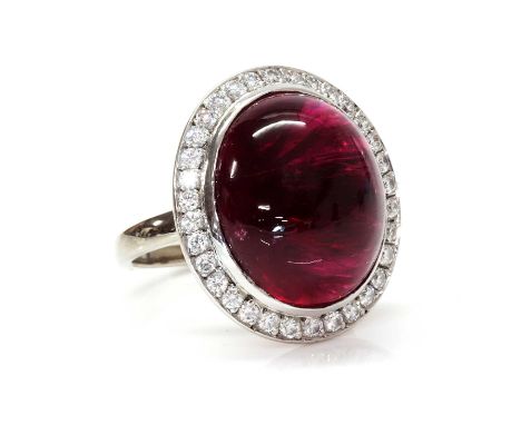 An Australian tourmaline and diamond cluster ring, by Jan Logan, with a cabochon pink tourmaline with a stated weight of 25.4