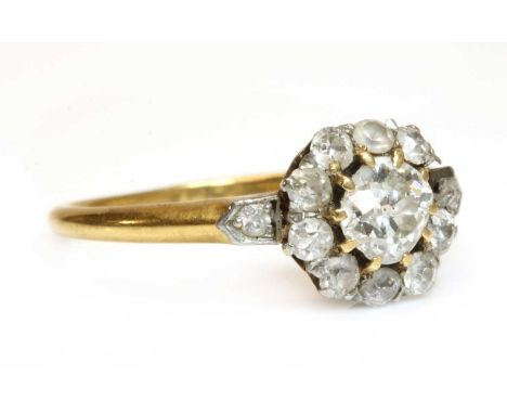 An Edwardian gold diamond cluster ring,with a cushion cut diamond, claw set to the centre. A border of Swiss cut diamonds, on