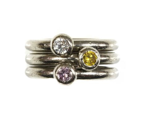 A set of three 18ct white gold diamond set stacker rings,with circular section round shanks and a single brilliant cut diamon