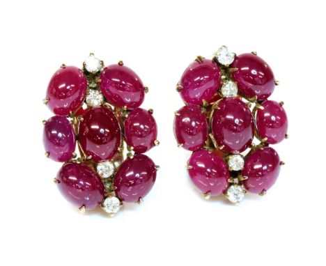 A pair of cabochon ruby and diamond earrings, c.1945,with a series of oval cabochon rubies, all claw set into a barrel shaped