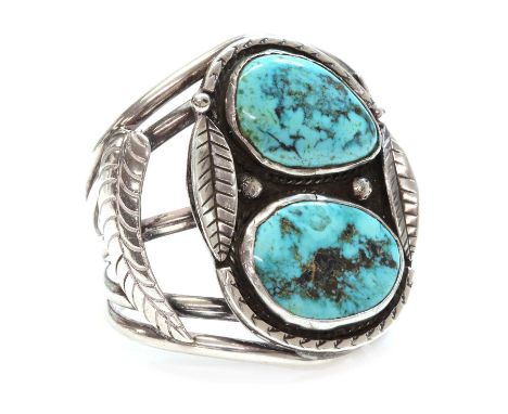 A silver Navajo turquoise set torque bangle or cuff,possibly c.1970, with two freeform turquoise cabochons, rub set to the to