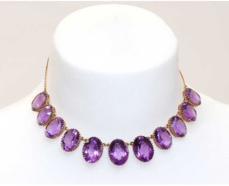 A late Victorian amethyst fringe necklace,with a row of graduated oval mixed cut amethysts, each one claw set in a pierced co