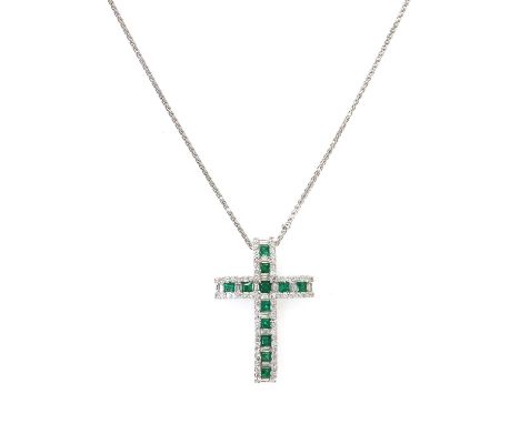 An 18ct white gold emerald and diamond Latin style cross,of looped form. Rows of slightly graduated calibre cut emeralds and 