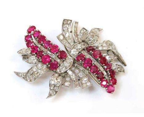 A ruby and diamond double clip brooch, c.1935-1940,composed of two matching, but inverted sprays. A central fern style frond,