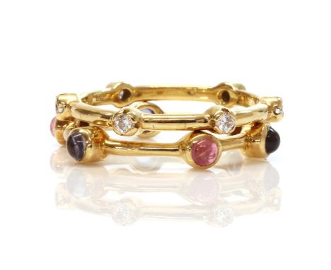 Two gold diamond and gem set stacking rings, by Ilias Lalaounis,with a central 'D' section plain band. One ring with brillian