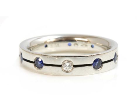 A Swiss platinum diamond and sapphire set band ring, by Furrer-Jacot,with a brilliant cut diamond and a row of circular mixed