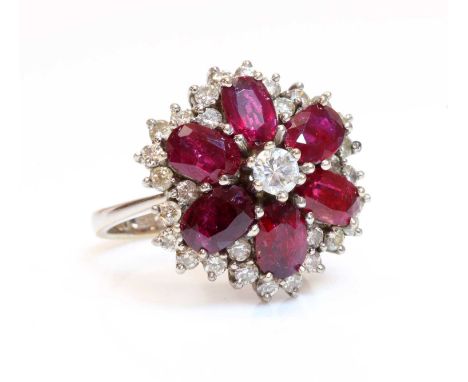 A diamond and ruby cluster ring,with a brilliant cut diamond, claw set to the centre. A surround of six mixed cut rubies, cla