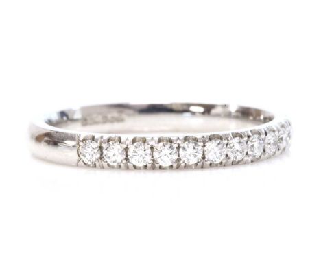 An 18ct white gold diamond set half eternity ring,with a row of brilliant cut diamonds, claw set to a court section band. 2.5
