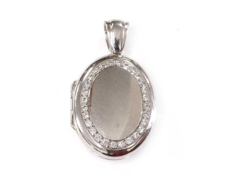 An 18ct white gold diamond set hinged locket, by Charles Green, of oval bombé form, with a border of brilliant cut diamonds, 