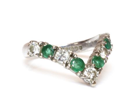 An 18ct white gold diamond and emerald half wishbone ring,with alternating brilliant cut diamonds and circular mixed cut emer