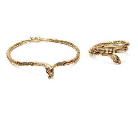 A 9ct gold snake bangle and necklace suite, c.1970,the necklace with a centrepiece of crossed snake head and tail, with ruby 