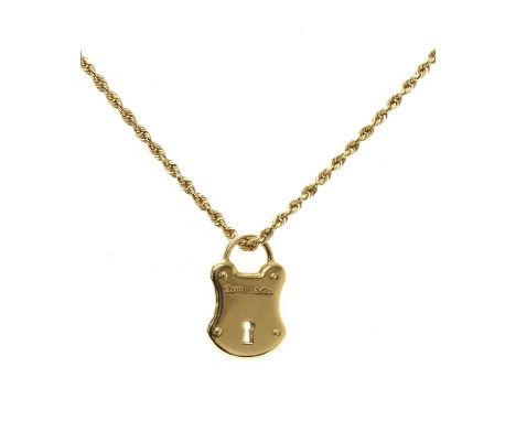 A gold slide pendant, by Tiffany &amp; Co., in the form of a padlock, suspended on a filed rope link chain with side lever cl
