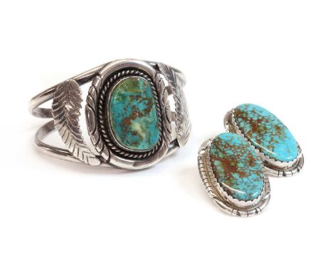 A silver Navajo torque style cuff bangle,with a freeform cabochon turquoise, rub set to the centre. A twisted wire border wit