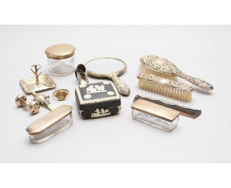 A collection of three silver topped dressing table jars, together with a silver backed hand mirror, two silver backed brushes