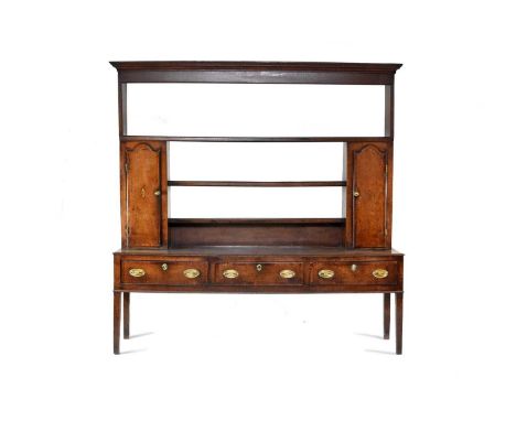 A George III oak and mahogany cross-banded dresser, Shropshire, the scotia cornice above a three-tier rack with spice cupboar