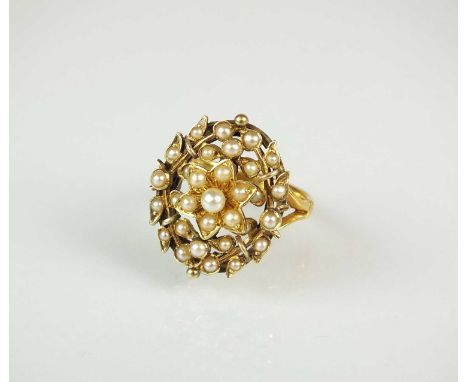 A seed pearl set ring, the floral seed pearl cluster within stylised wreath, mounted to split shoulders, the yellow metal sha