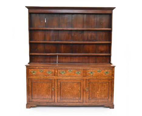 A George III oak dresser with rack, the convex cornice above a three-tier plate rack with fruitwood back-boards, the base wit