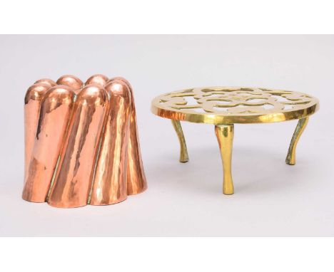 A group of Edwardian and later copper and brassware, including a brass trivet, a copper jelly mould, various brass fire tools