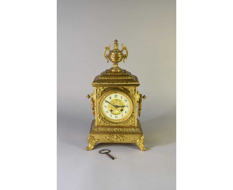 A French gilt brass mantel clock, circa 1890-1900, with vase finial and moulded ring handles, the case cast with neoclassical