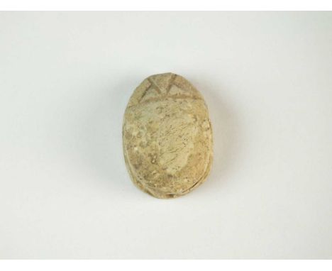 Faience scarab with plain body and just the head area defined, the legs folded to the side of the body; pierced for suspensio