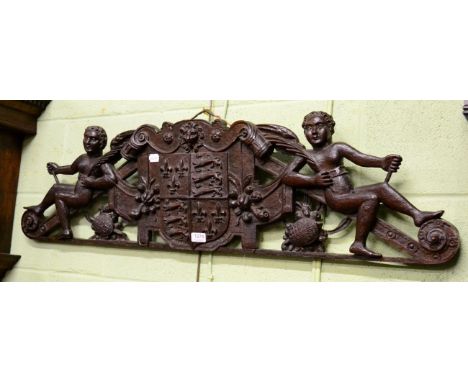 A 19th century wall carving depicting two winged cherubs flanking a coat of arms 