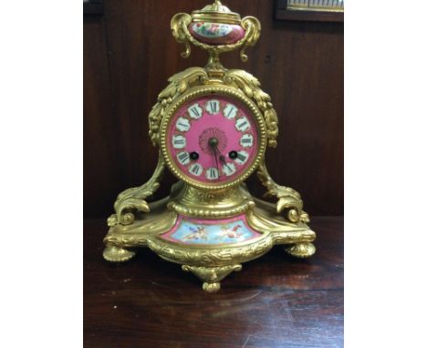 A French gilt mantle clock of classical style inset with pink panels, no pendulum.