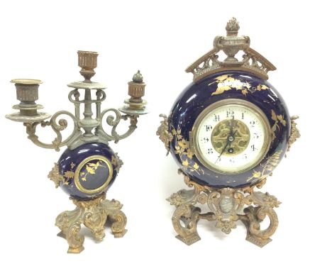 A brass and enamel table clock with candelabra garniture. 29 & 24cm tall approximately. Postage category D