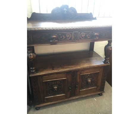 A carved late Victorian oak buffet with a raised back above carved drawers and cupboards. 106cm wide 108cm high.- NO RESERVE