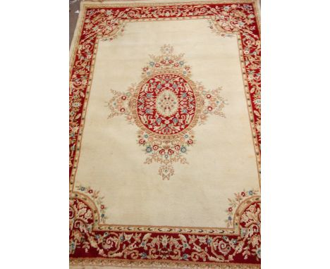 Indian carpet, central medallion over cream ground red floral border, 270cm x 348cm Condition Report Click here for further i