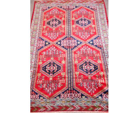 Turkoman carpet with quadruple red panels enclosing blue medallions triple border, 343cm x 243cm Condition Report Click here 