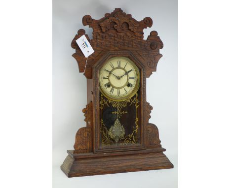 Late 19th century American ginger bread mantle clock, scrolling pediment, over glass door, enclosing white painted dial, Roma