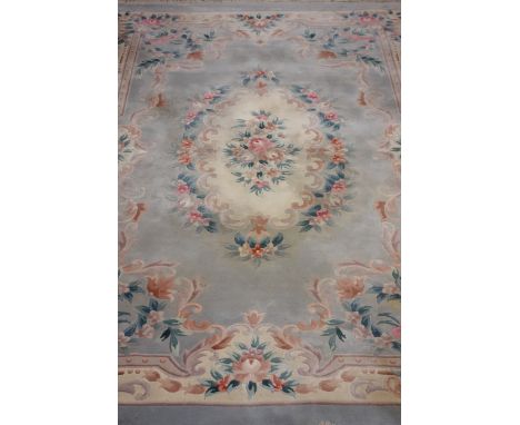 Chinese washed woollen carpet central floral medallion over faded light blue ground floral spandrels and border, 284cm x 182c