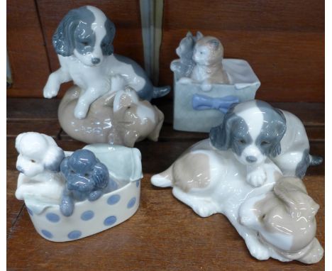 Four Nao by Lladro figure groups, Kittens in a Basket, Poodles in a Polka Dot Box and two puppy figures 